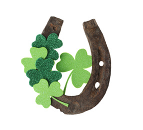 Photo of Old horseshoe and clover on white background. St. Patrick's Day celebration