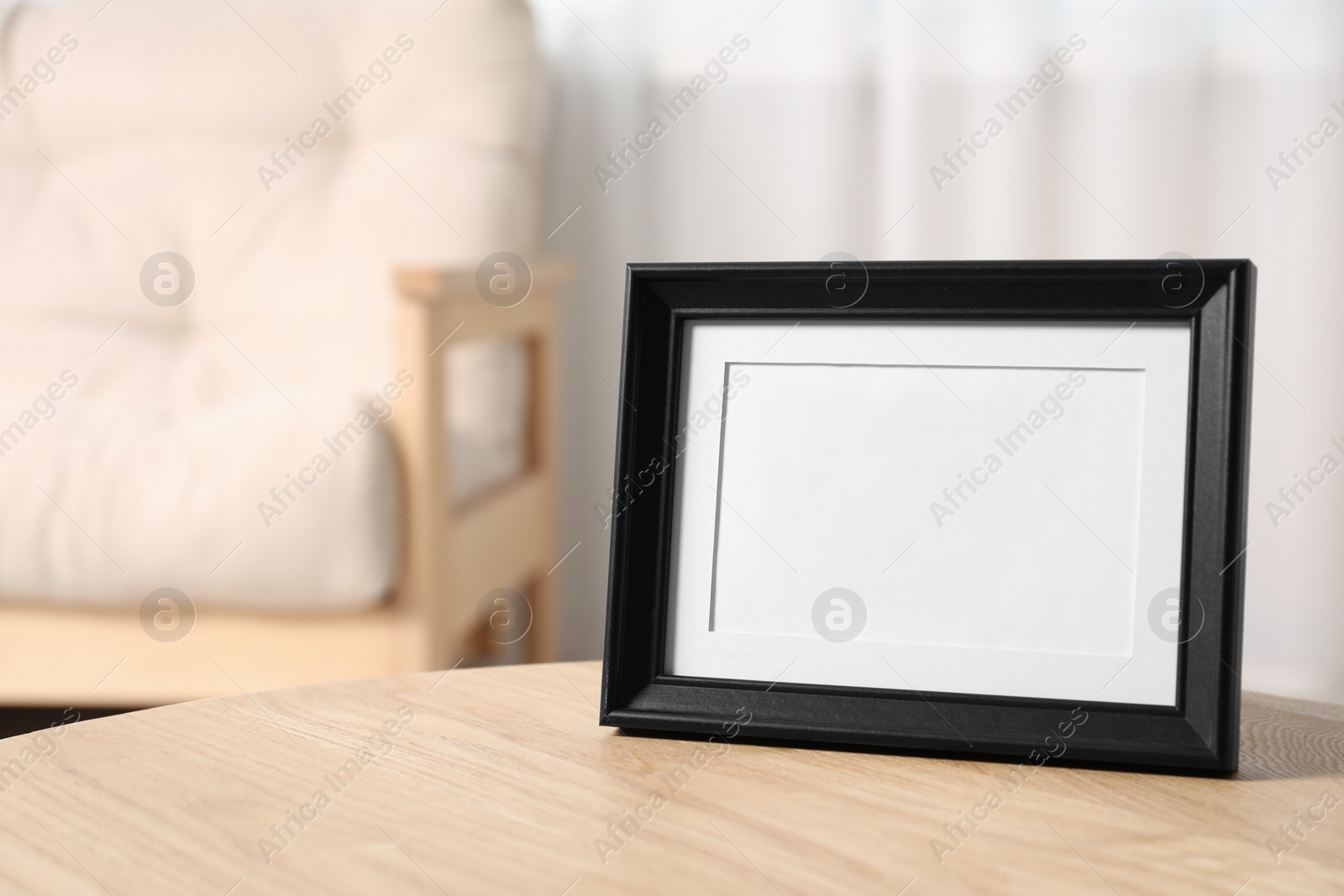 Photo of Empty photo frame on wooden table, space for text