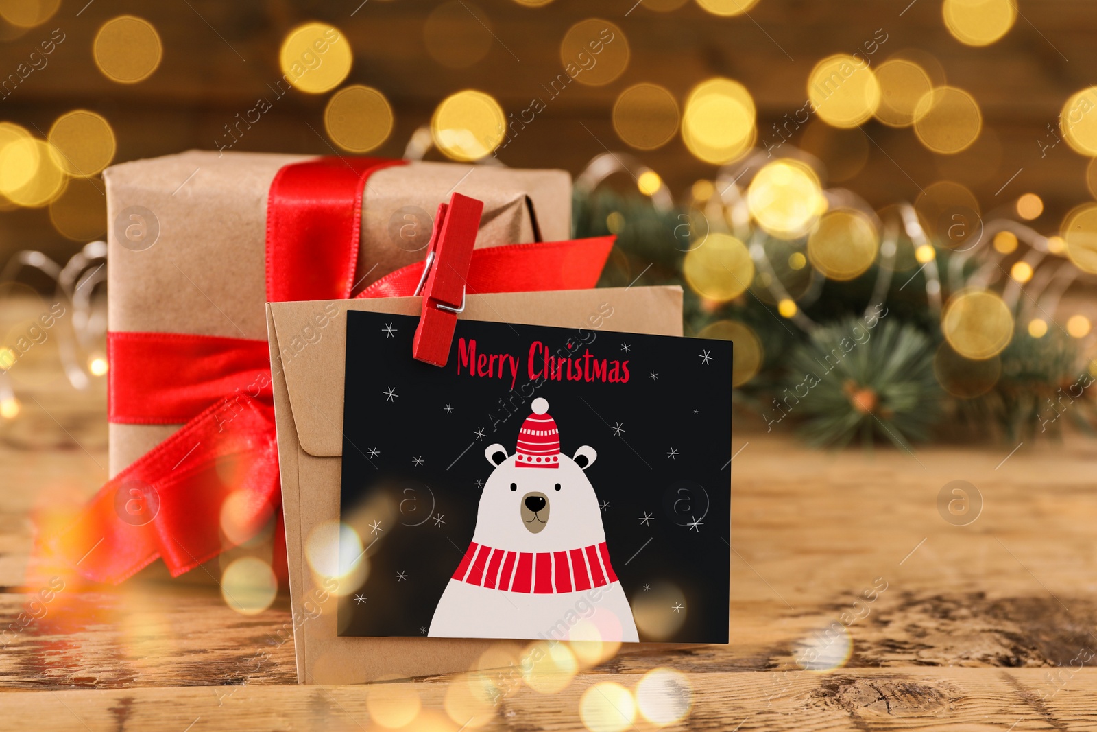 Image of Greeting card with text Merry Christmas and gift on wooden table