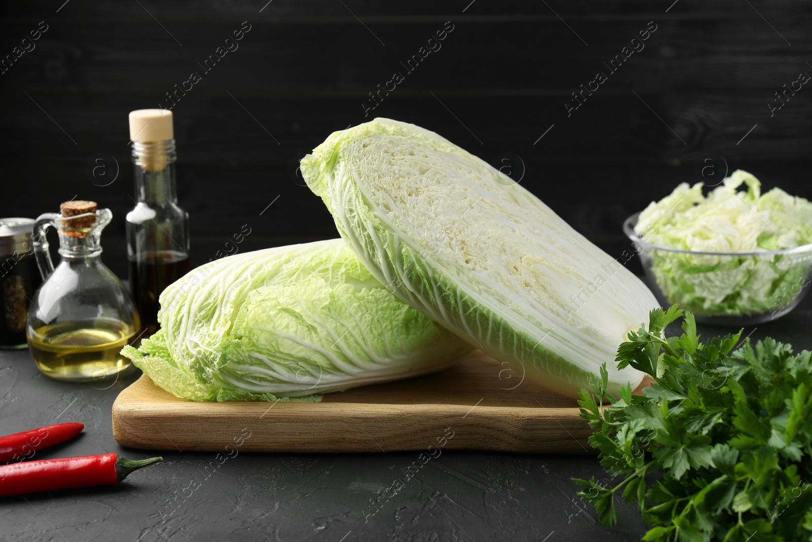 Photo of Fresh Chinese cabbages and other products on black textured table