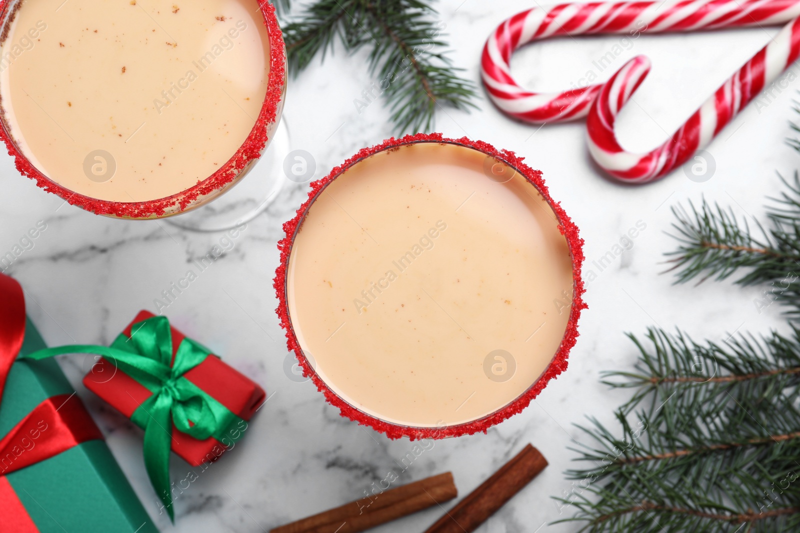 Photo of Delicious Christmas liqueur on white marble table, flat lay