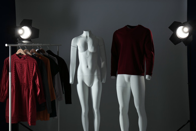 Ghost mannequins, clothes and professional lighting equipment in modern photo studio