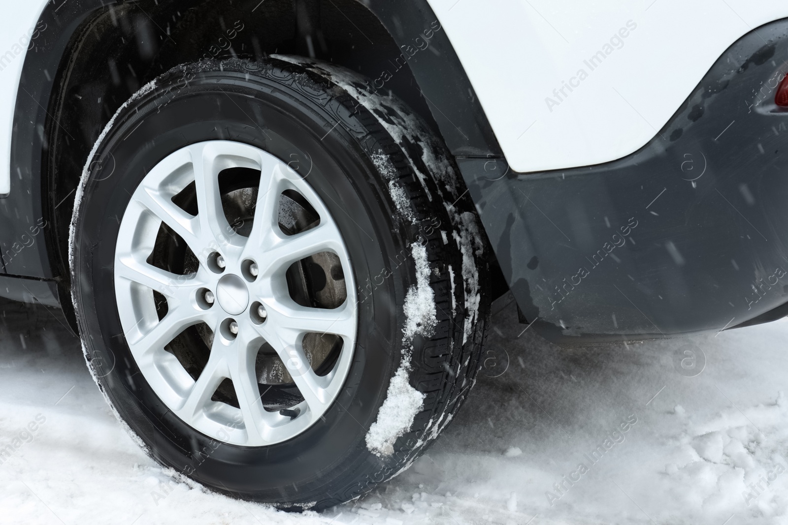 Photo of Modern car on snowy winter road, closeup