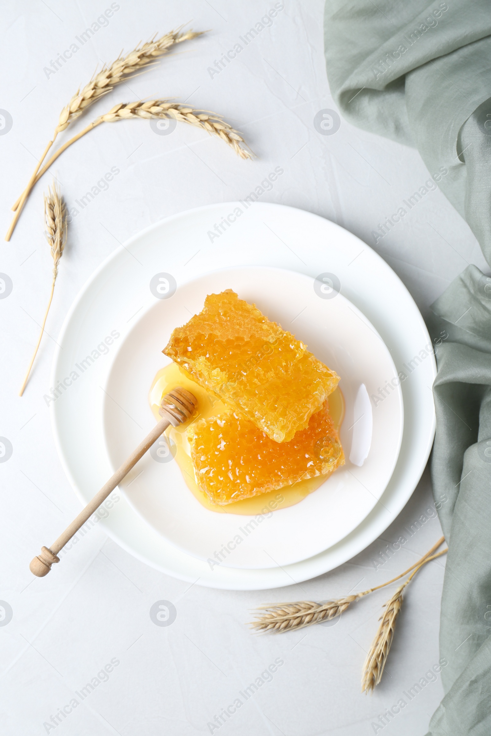 Photo of Natural honeycombs with tasty honey and dipper on white table, flat lay