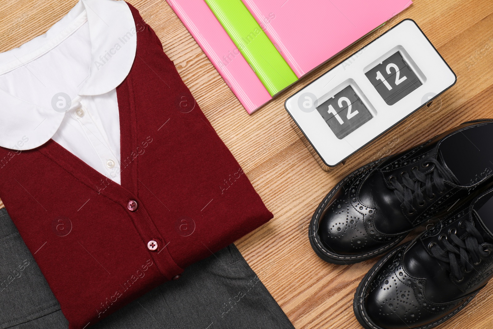 Photo of School uniform for girl and stationery on wooden background