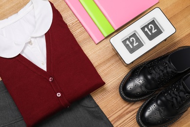 Photo of School uniform for girl and stationery on wooden background