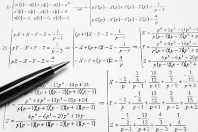 Photo of Sheet of paper with mathematical formulas and pen