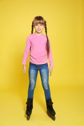 Photo of Full length portrait of girl with inline roller skates on color background