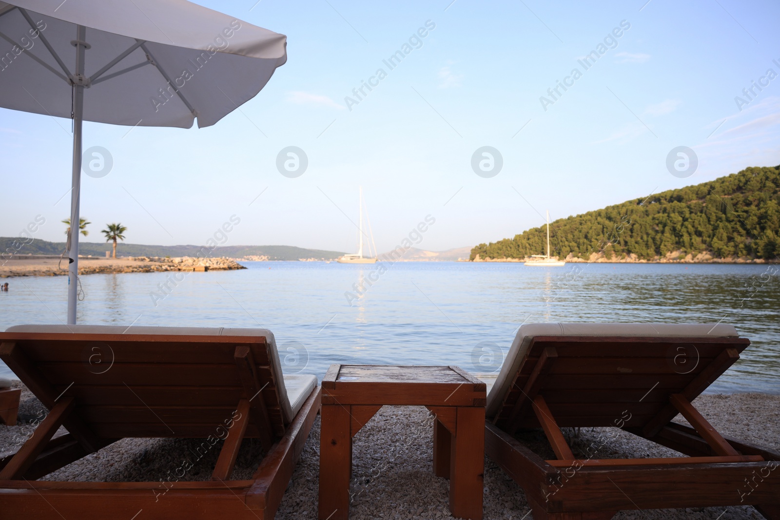 Photo of White beach umbrella and sunbeds at resort