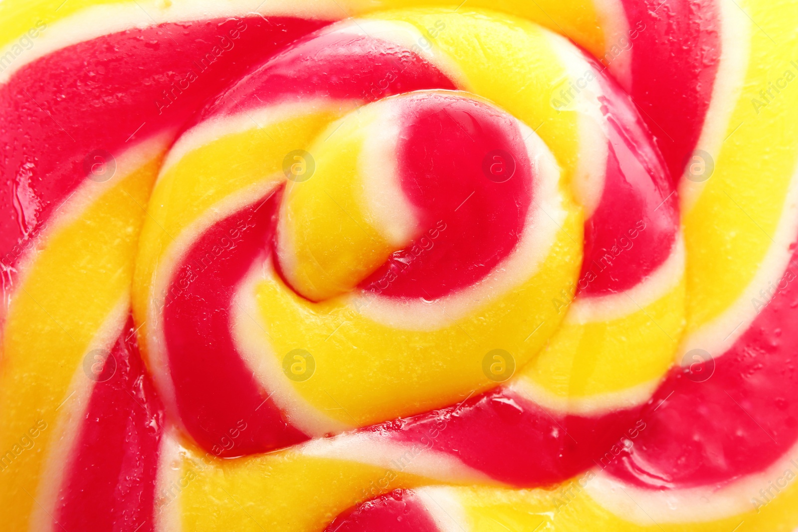 Photo of Sweet colorful lollipop on pink background, closeup view. Delicious candy