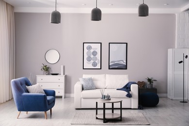 Stylish living room interior with white sofa, armchair and small coffee table