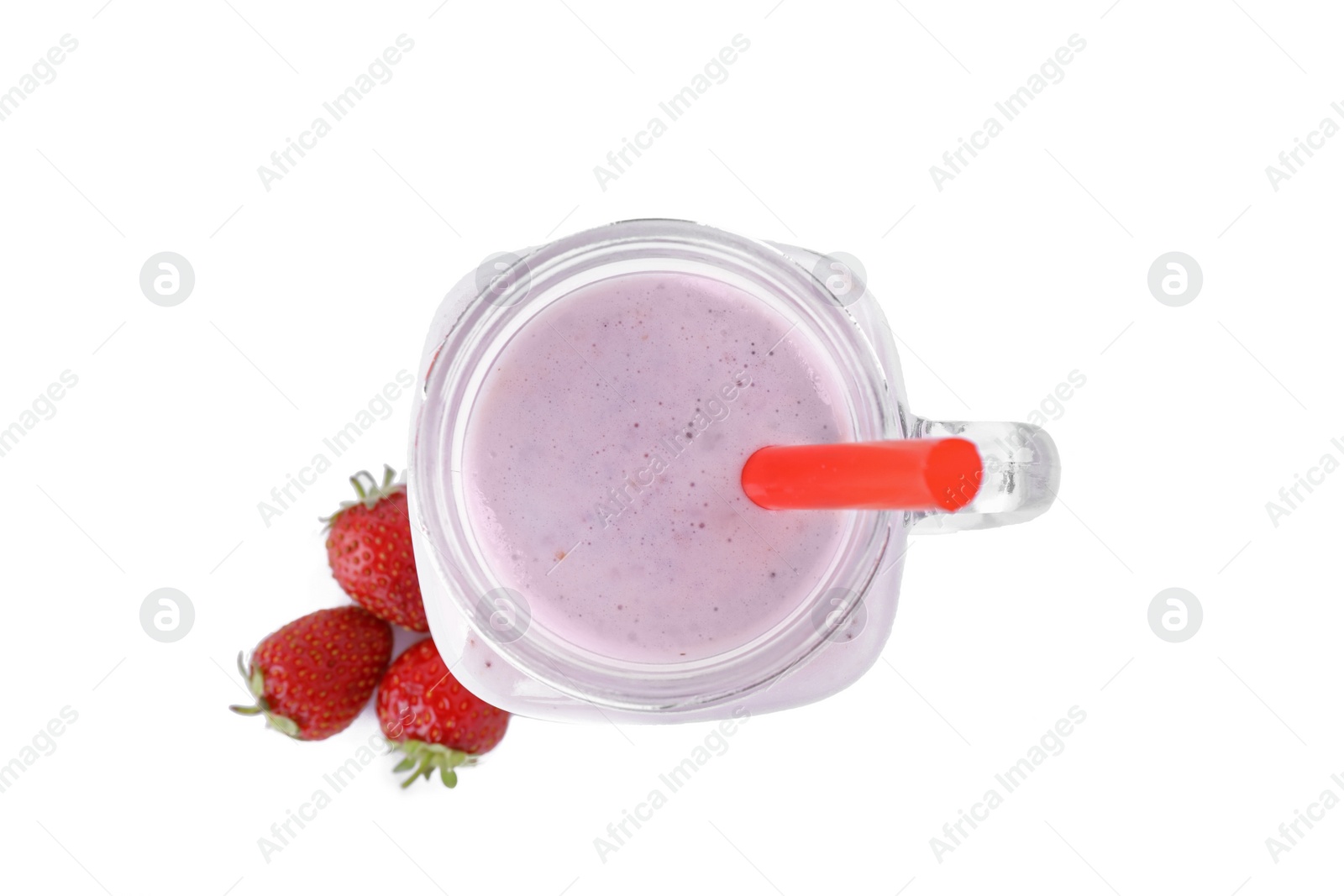 Photo of Tasty fresh milk shake in mason jar with strawberries on white background, top view