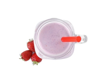 Photo of Tasty fresh milk shake in mason jar with strawberries on white background, top view