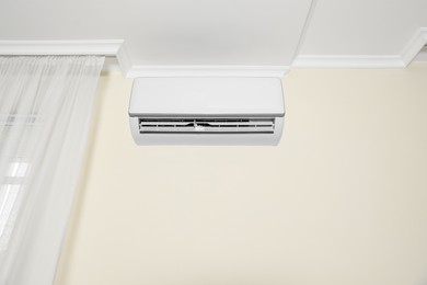 Modern air conditioner on white wall indoors