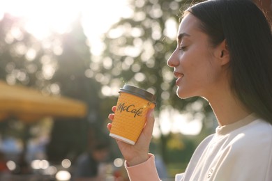 Photo of Lviv, Ukraine - September 26, 2023: Woman with hot McDonald's drink outdoors, space for text