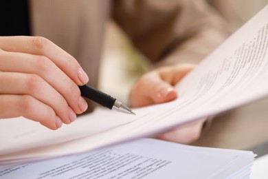 Photo of Woman signing documents in office, closeup view