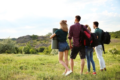 Photo of Group of young people with backpacks in wilderness. Camping season