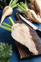 Photo of Whole and cut sugar beets on blue wooden table