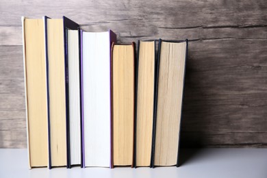 Photo of Collection of different books on white shelf, space for text