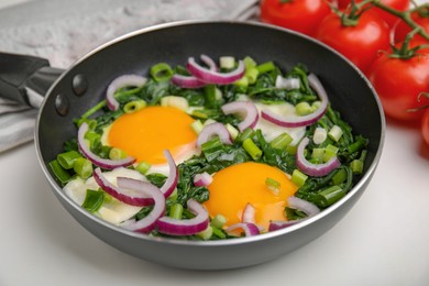 Tasty green shakshuka on white table, closeup