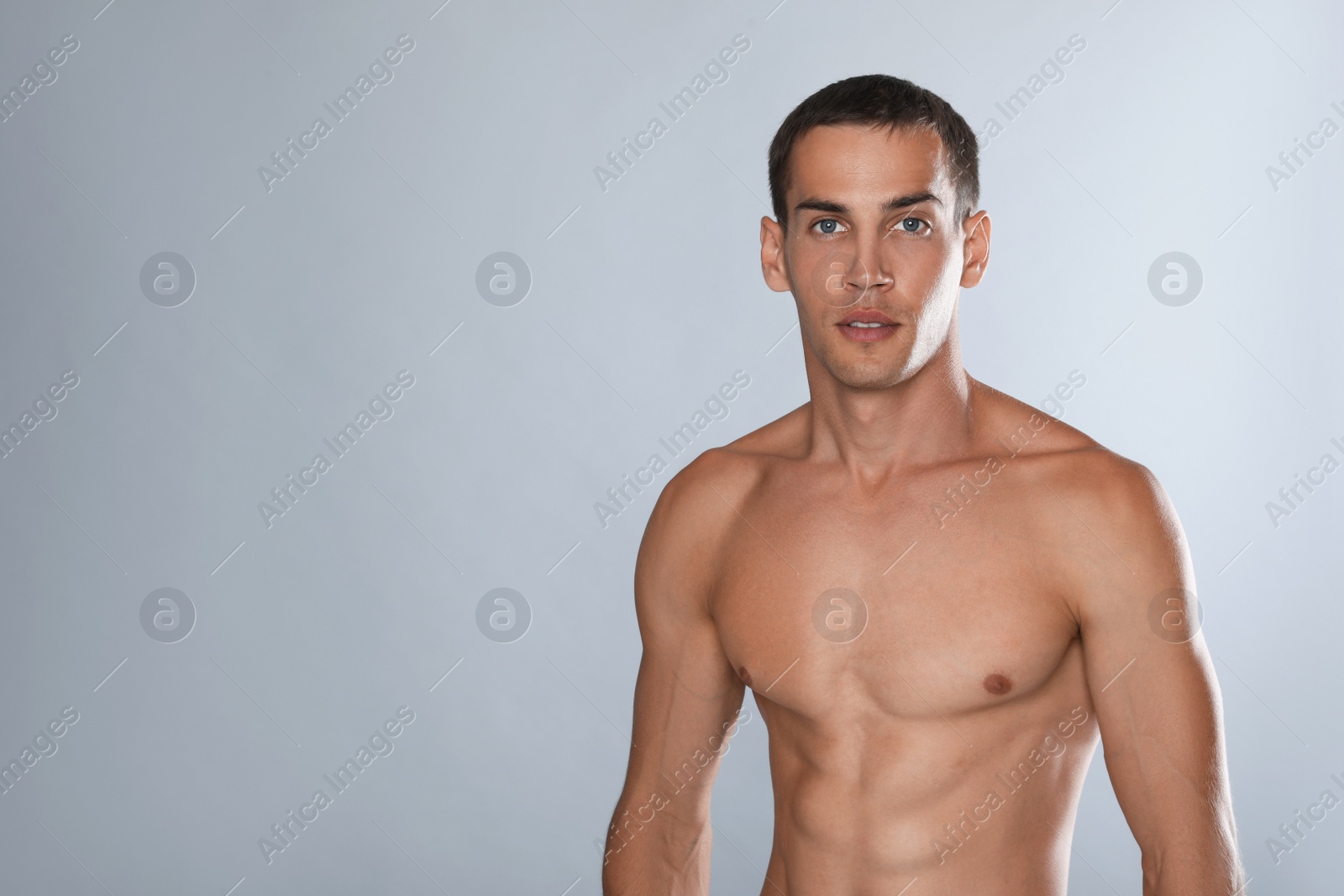 Photo of Handsome shirtless man with slim body on grey background. Space for text