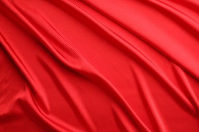 Photo of Crumpled red silk fabric as background, top view