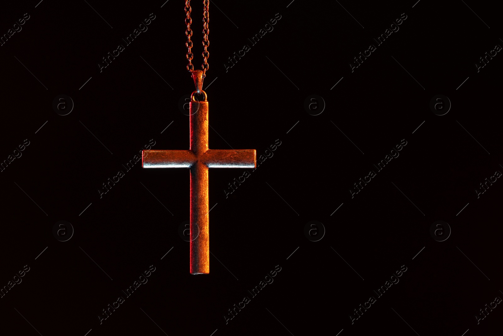 Photo of One cross with chain on black background, space for text. Religion of Christianity