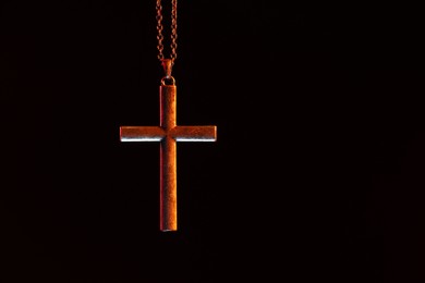Photo of One cross with chain on black background, space for text. Religion of Christianity
