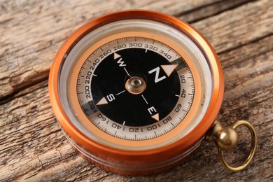 One compass on wooden table, closeup. Tourist equipment