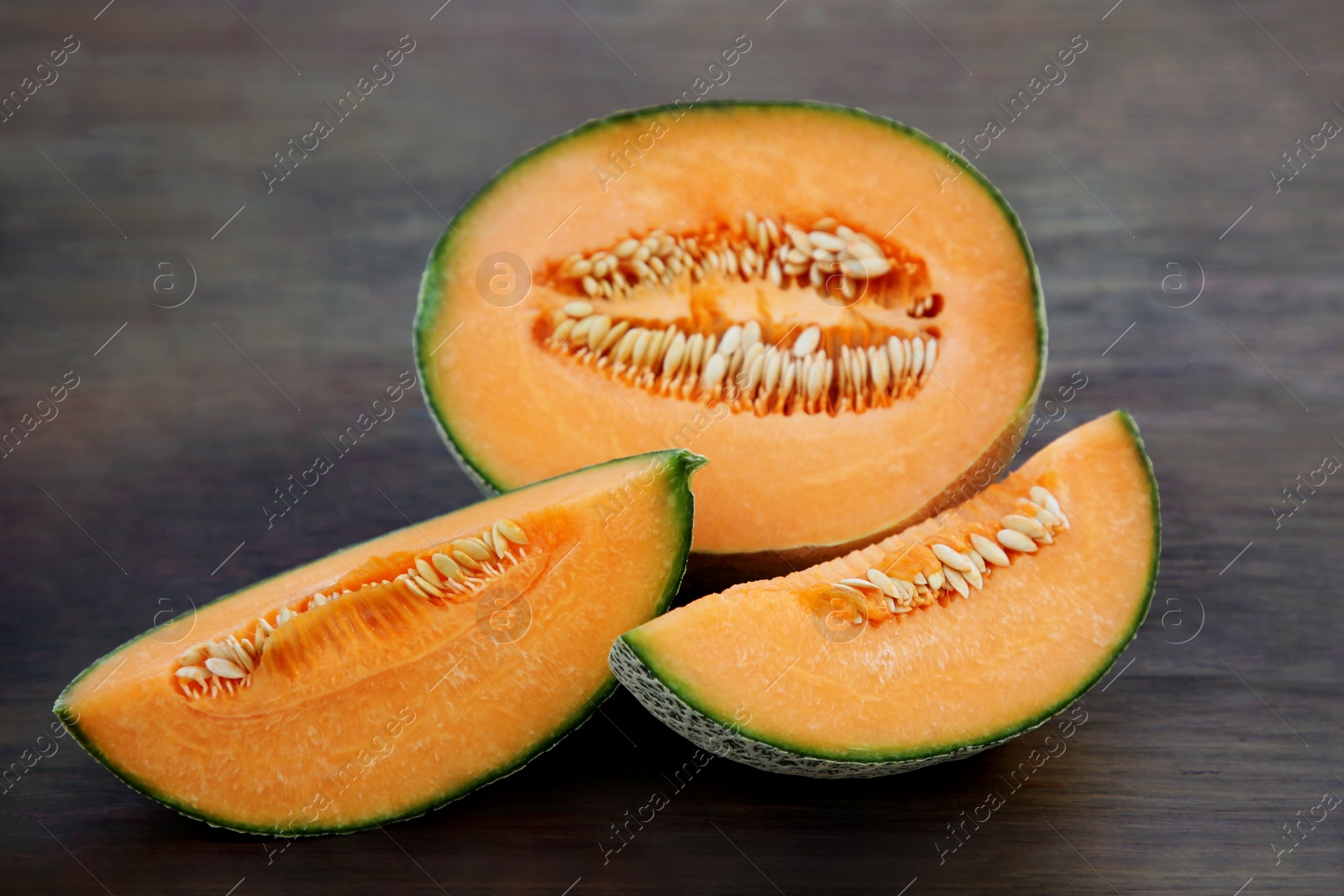 Photo of Tasty orange ripe melons on wooden table