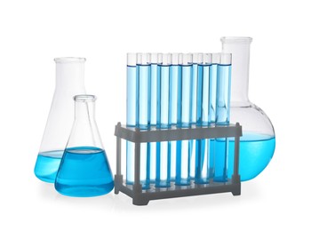 Photo of Different laboratory glassware with light blue liquid on white background