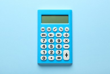 Photo of Light blue calculator on turquoise background, top view