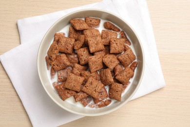 Photo of Bowl with tasty corn pads and milk on wooden table, flat lay