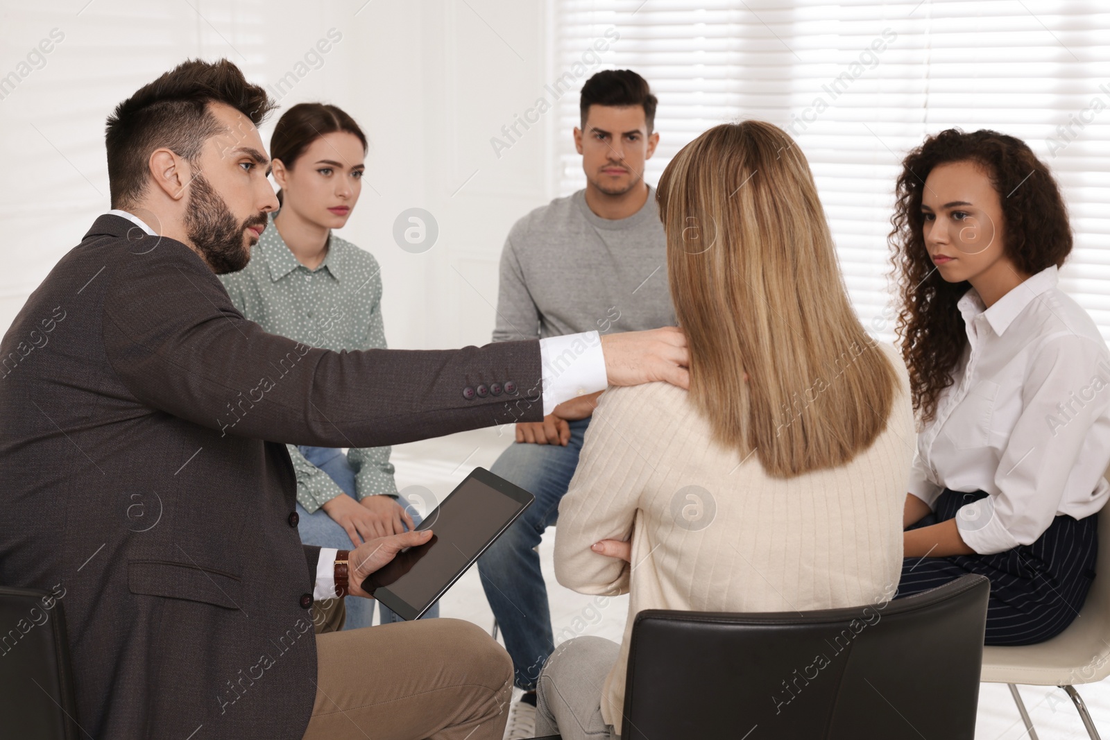 Photo of Psychotherapist working with patients at group session indoors