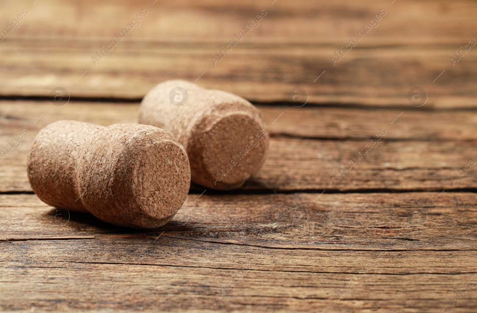 Photo of Corks of wine bottles on wooden table, closeup. Space for text