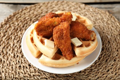 Photo of Delicious Belgium waffles served with fried chicken drumsticks and butter on table, closeup