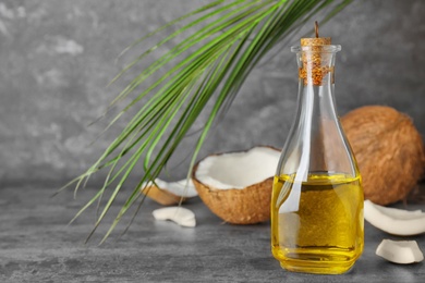 Photo of Ripe coconut and oil in bottle on table. Healthy cooking