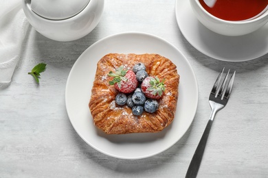 Fresh delicious puff pastry with sweet berries served on light table, flat lay