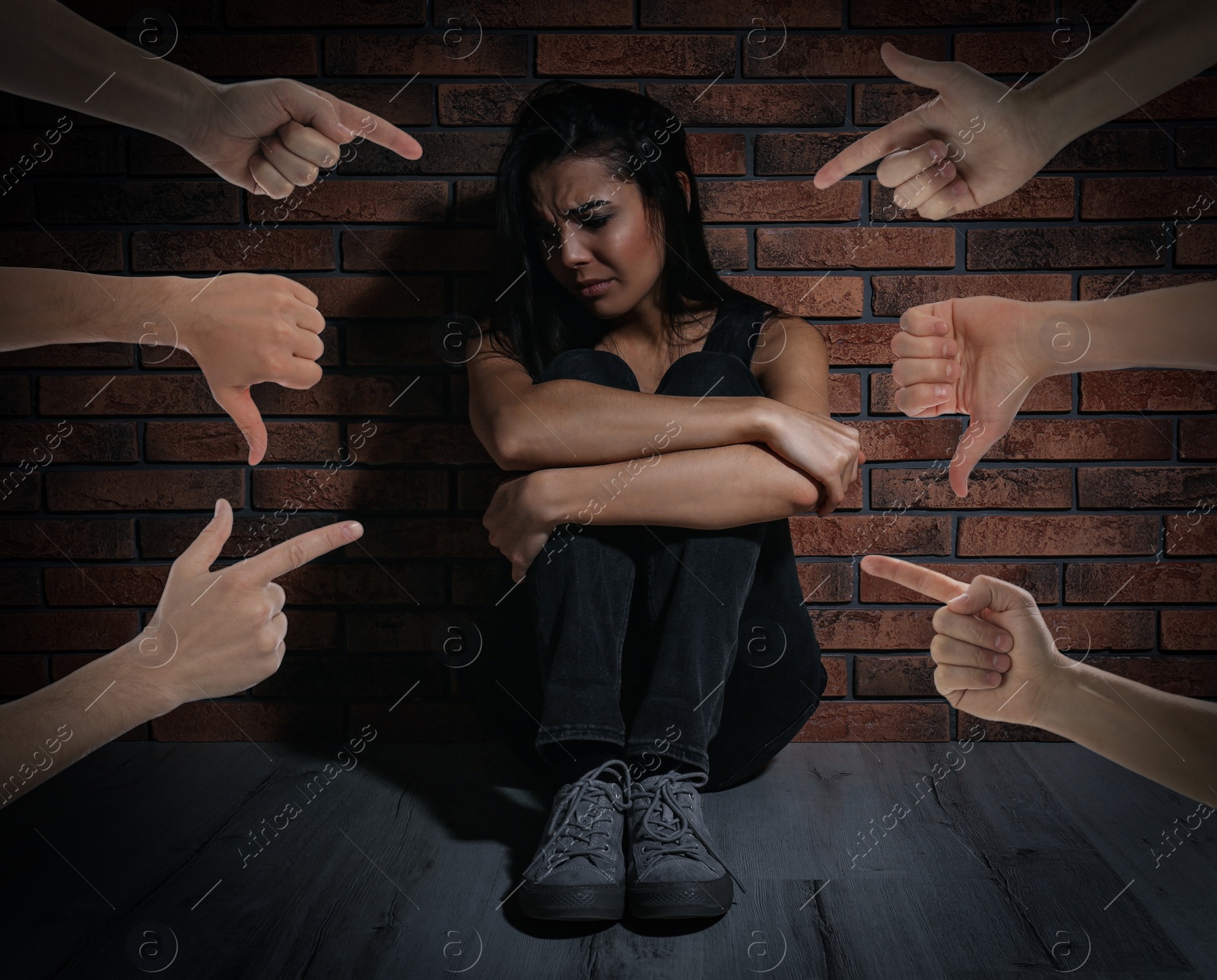 Image of People bullying young woman near brick wall