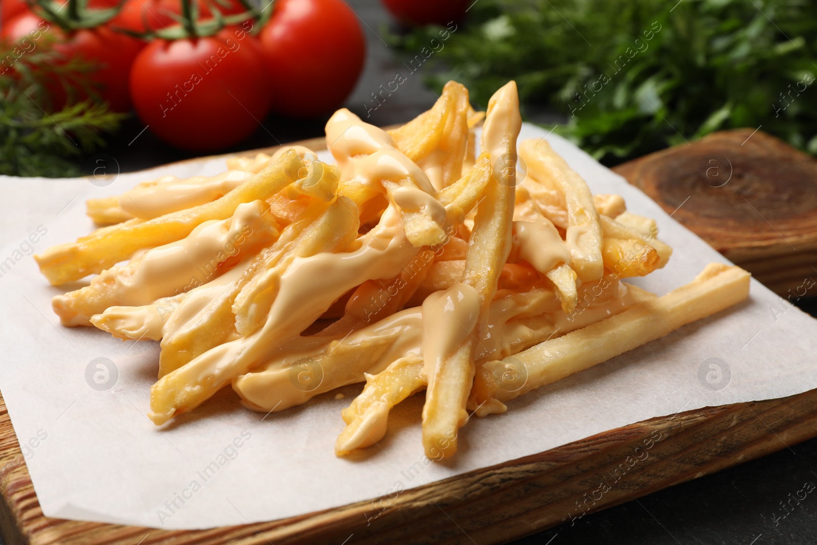 Photo of Delicious French fries with cheese sauce on table, closeup