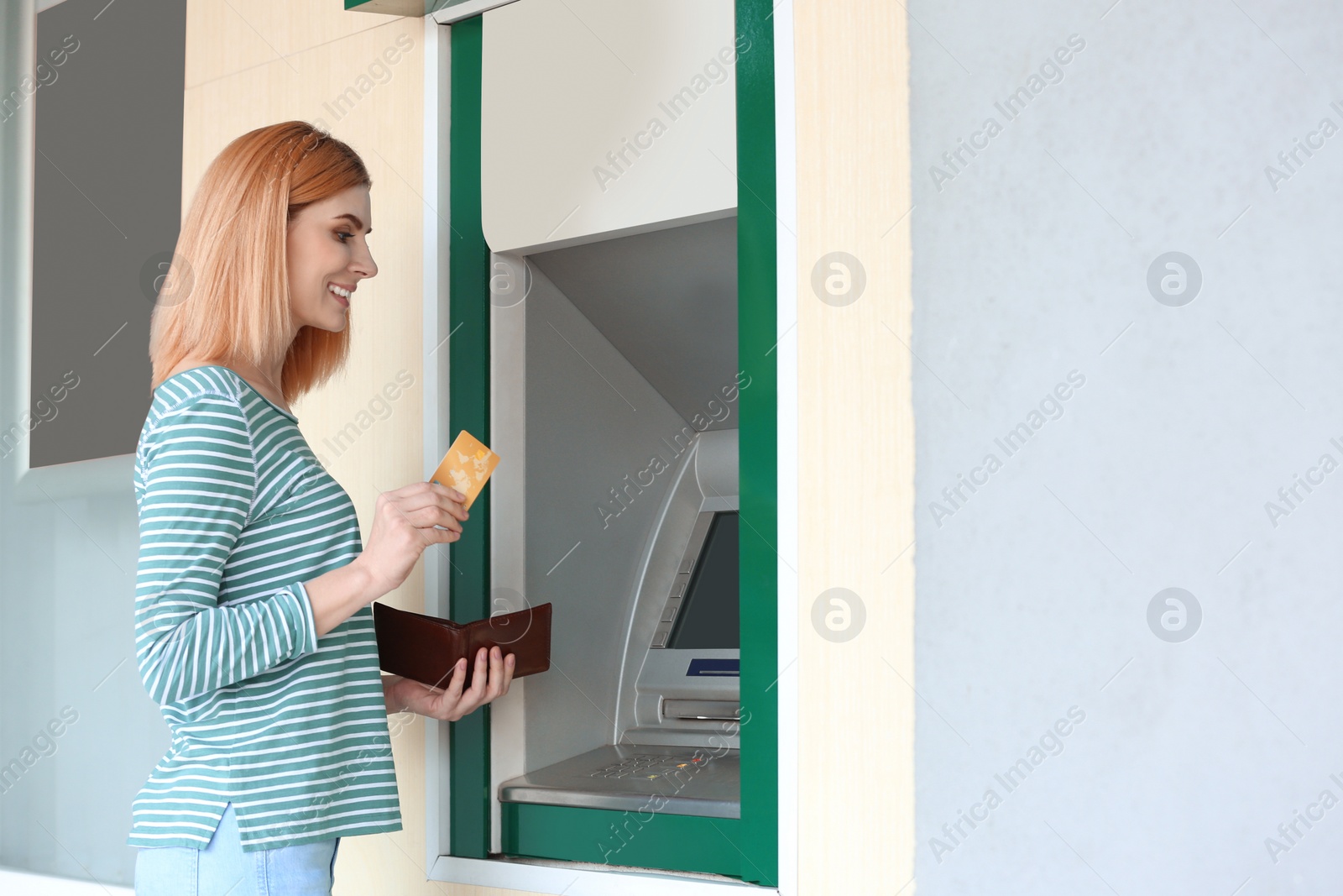 Photo of Beautiful woman with credit card near cash machine outdoors, space for text