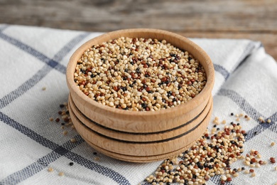 Photo of Bowl with mixed quinoa seeds on cloth