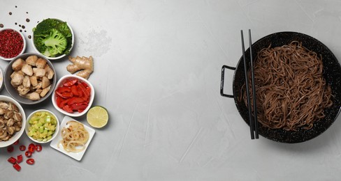 Photo of Wok with noodles, chicken and other products on light grey table, flat lay. Space for text