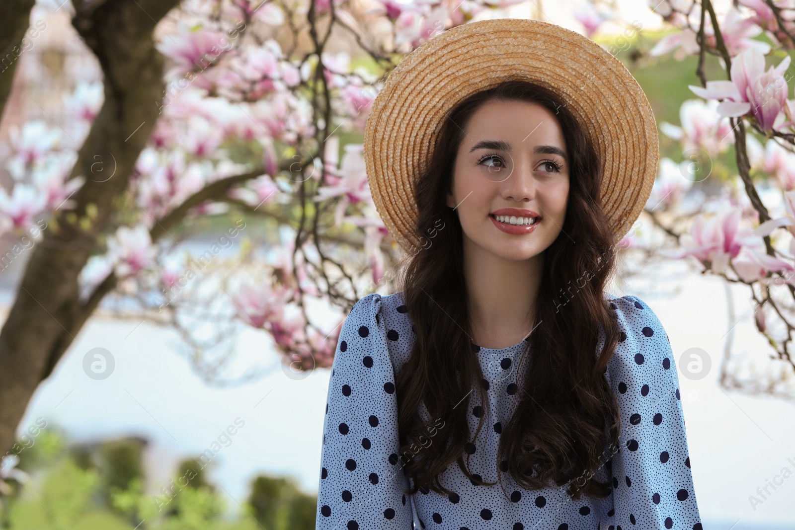 Photo of Beautiful woman near blossoming magnolia tree on spring day