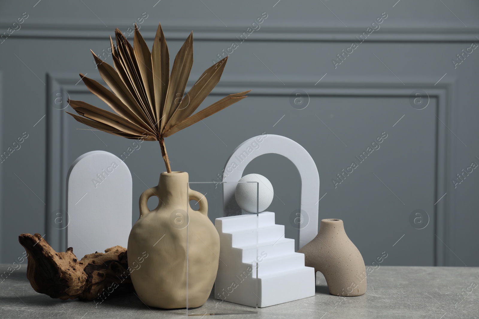 Photo of Clay flagon and other decorative elements on grey textured table, space for text