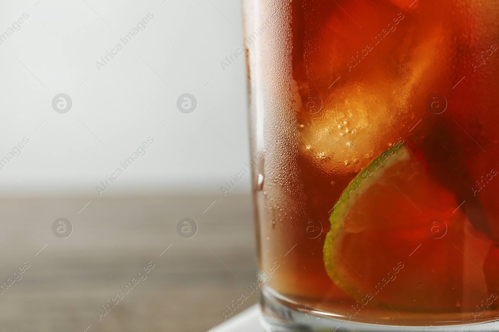 Photo of Glass of refreshing iced tea, closeup. Space for text