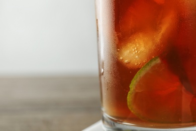 Glass of refreshing iced tea, closeup. Space for text
