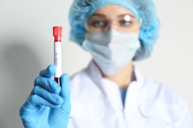 Photo of Scientist holding test tube with blood sample, focus on hand