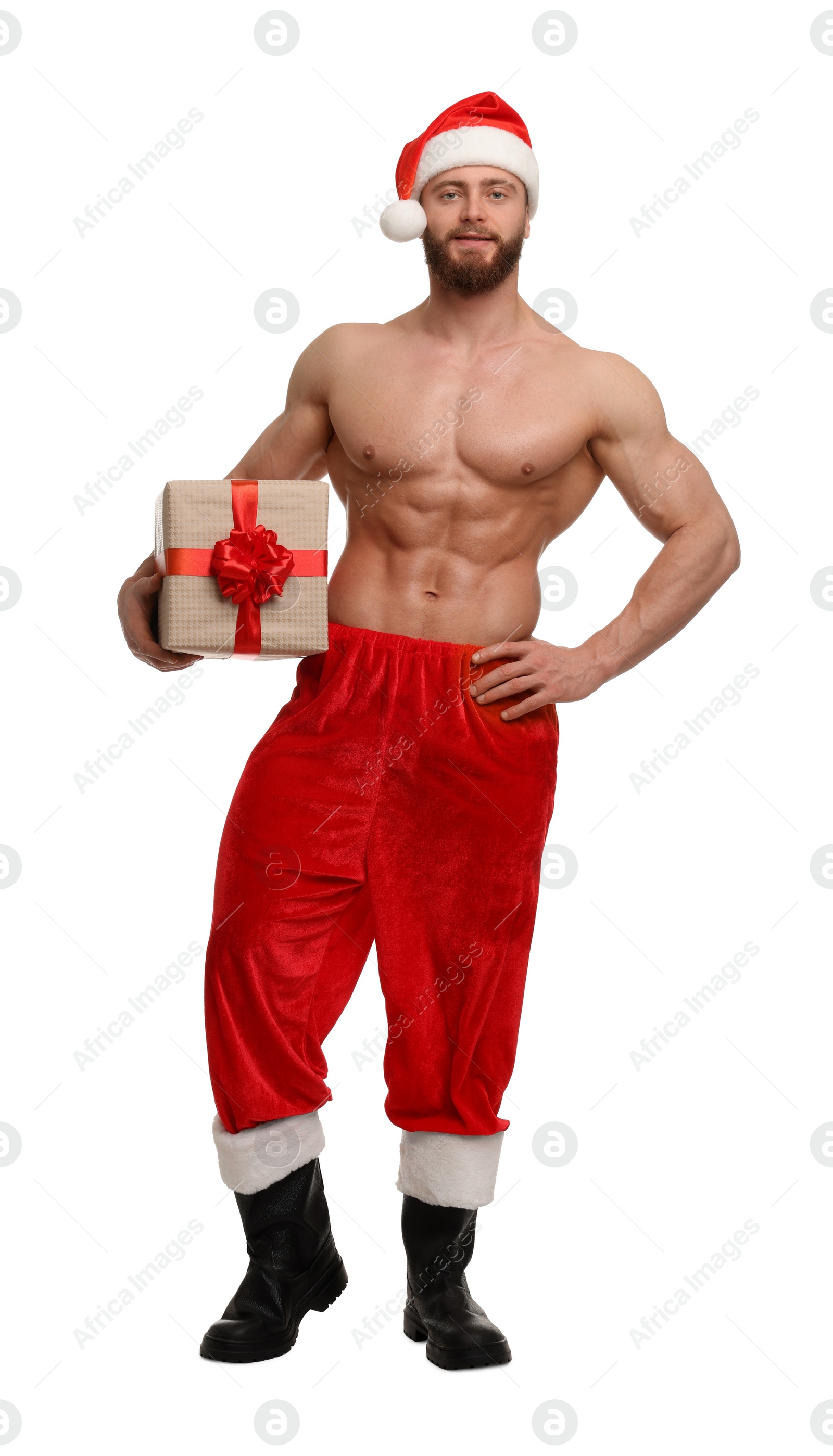 Photo of Attractive young man with muscular body in Santa hat holding Christmas gift box on white background