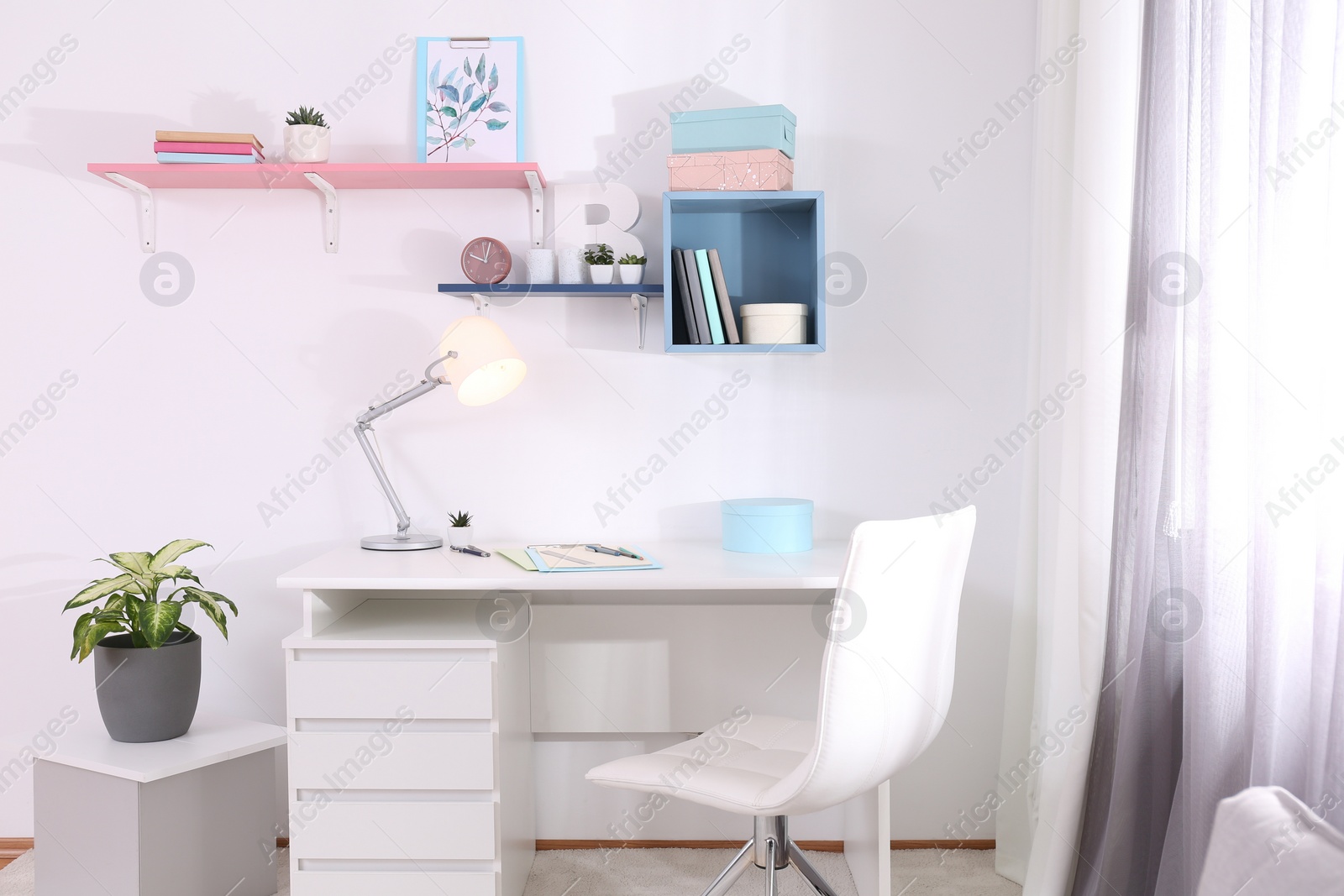 Photo of Stylish room interior with comfortable workplace near window. Design idea